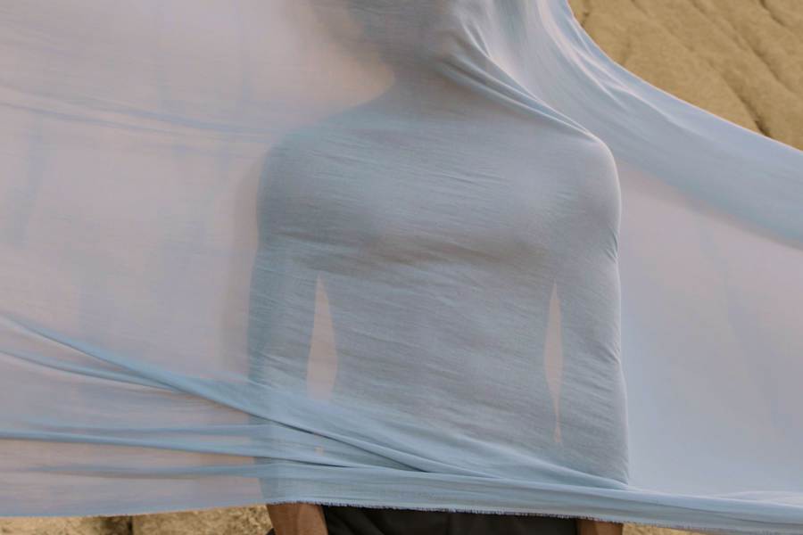 Person with bed sheets flying over them